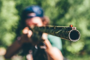 A person pointing a shotgun